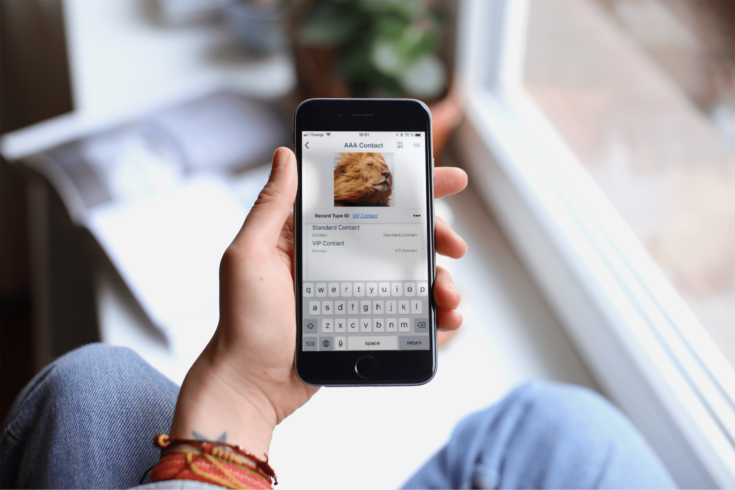 hand holding a smartphone with contact card